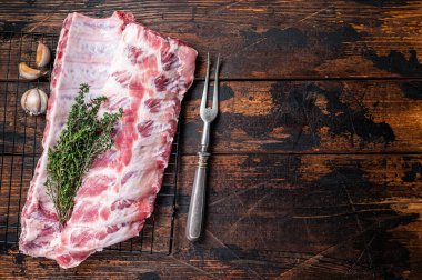 Çiğ domuz pirzolası ve şifalı otlar. Ahşap arka plan. Üst Manzara. Boşluğu kopyala.