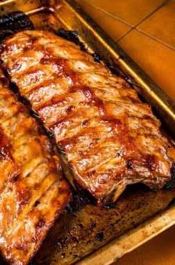 Barbecue grilled pork spare ribs. Orange background. Top view.