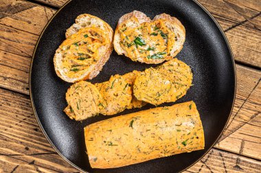 Butter with flavoring additives, sandwich butter with fresh herbs, sweet peppers, lemon, onion, garlic. Wooden background. Top view.