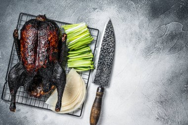 Whole roast Peking duck with herbs, sauce, rice Pancake, Cucumber and onion. White background. Top view. Copy space.