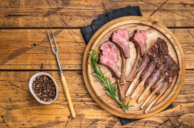 Izgara kuzu pirzolası, ahşap tahtada kuzu eti bifteği. Ahşap arka plan. en üstteki görünüm.