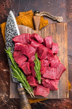 Doğranmış çiğ geyik eti, kasap kesim tahtasında taze Wild Roe Geyiği eti. kahverengi arka plan. en üstteki görünüm.