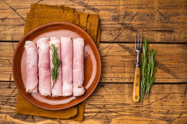 İtalyan Dilimlenmiş Prosciutto Cotto salamı tabakta. Ahşap arka plan. en üstteki görünüm.