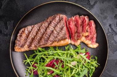 BBQ rump Cap bifteği, Brezilya Picanha tabağında salata. Siyah arka plan. en üstteki görünüm.