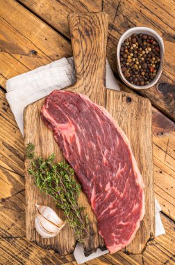 Çiğ biftek, pişmemiş et, zengin mermer ve canlı rengini gözler önüne seriyor. Ahşap arka plan. en üstteki görünüm.