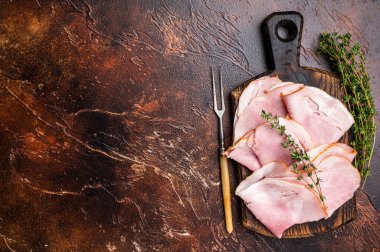 Jambonlu Prosciutto Cotto, dilimlenmiş domuz pastırması tahtada. kahverengi arka plan. en üstteki görünüm.