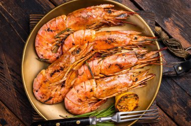 Izgara kırmızı Arjantin karidesi, karides Langostino Austral ve şifalı otlar. Ahşap arka plan. en üstteki görünüm.