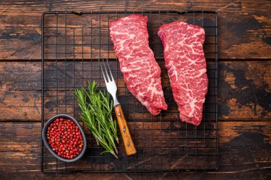 Sığır omzu yumuşak, çiğ Denver bifteği gurme tabağına dönüşmeyi bekliyor. Unutulmaz bir akşam yemeği için ızgara ya da kızartma için ideal. Ahşap arka plan. en üstteki görünüm.