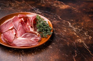Balkan Prsut kapağı, dilimlenmiş domuz etli jambon tabağı. kahverengi arka plan. en üstteki görünüm.
