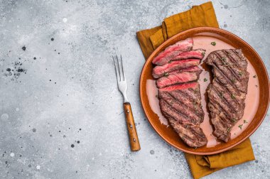 Yumuşak, düz demir biftek, doğal tadını ve hassasiyetini arttırmak için ızgara. Gri arkaplan. en üstteki görünüm.
