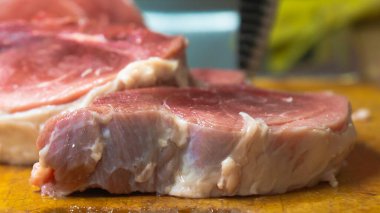Rural cuisine. Cooking pork in a home country kitchen. Cut tenderloin for steak.