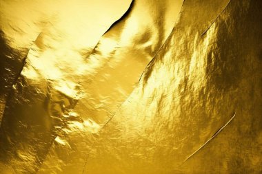 Gold foil background with light reflections. Golden textured