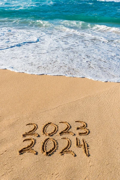 2023 2024 Written Sand Wave Washing New Year Concept lizenzfreie Stockbilder