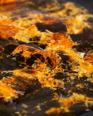 Koyu kağıda kırılmış kenevir cilası. Altın parçacıklı marihuana reçinesi.