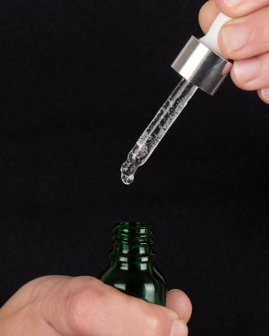 Fotokopi alanı olan bir pipet, koyu arkaplanda gerekli yağı gevşetin..