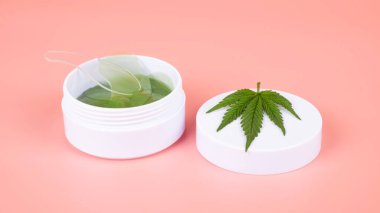 Pembe arka planda tıbbi marihuana göz bantları, esrar kozmetik cilt bakımı.