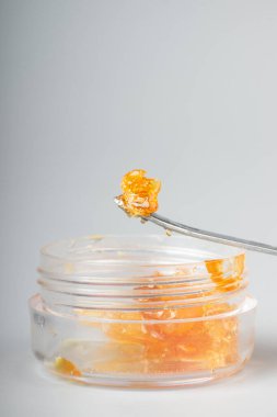 Yüksek oranda esrar tüttüren altın renkli cam kutu. Yaklaş ve hafifçe bastır..