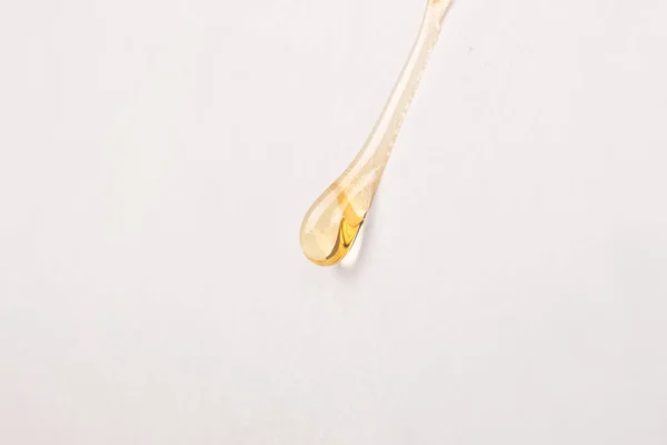 stock image cannabis wax resin golden drop down on white paper closeup.