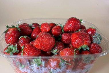 Çilekler bej arka planda yakın plan çekimde..