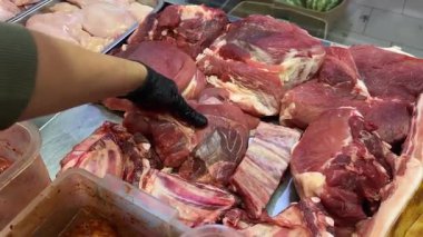 Satıcı tezgahın arkasında mağazanın stoğunda ne kadar taze et olduğunu gösteriyor. Yüksek kalite 4k görüntü