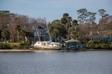 New Smyrna Beach, Florida, United States - December 30, 2022: A large wrecked sailboat beached on the coast of the Intracoastal Waterway. It was washed ashore during hurricane Nicole in November of 2022.