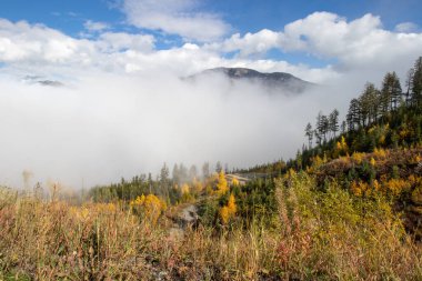 7. dağdaki bir sonbahar gününde dağların ve bulutların arasından görünen dağ manzarası..