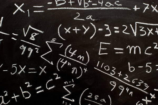 Mathematical formulas and equations written on a blackboard with chalk