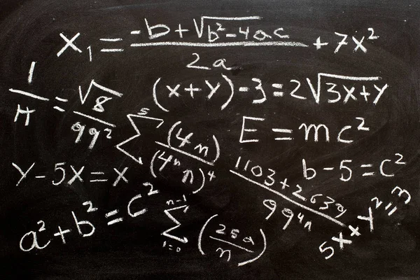 Mathematical formulas and equations written on a blackboard with chalk