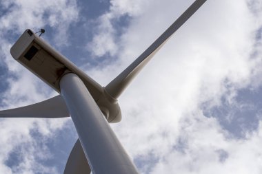 Detail of the blades of a wind turbine with the sky and clouds in the background