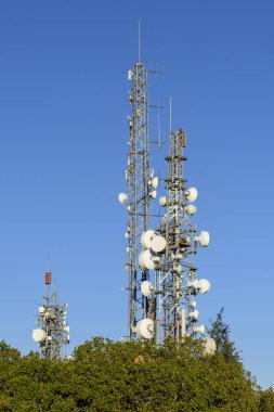 Arka planda mavi gökyüzü olan telekomünikasyon kuleleri