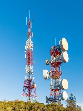 Arka planda mavi gökyüzü olan telekomünikasyon kuleleri