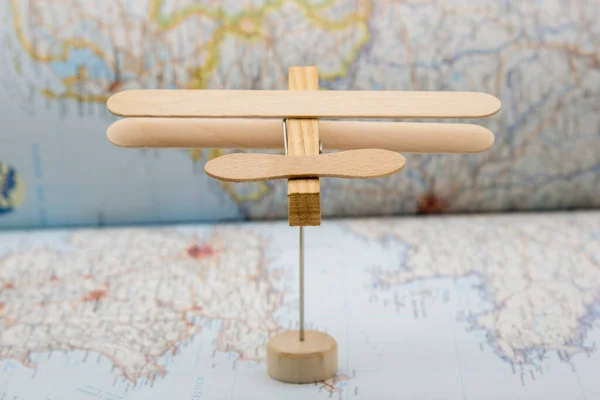 アイスクリームスティックと布ピンで作られた木製の飛行機は 地図上を飛んで — ストック写真