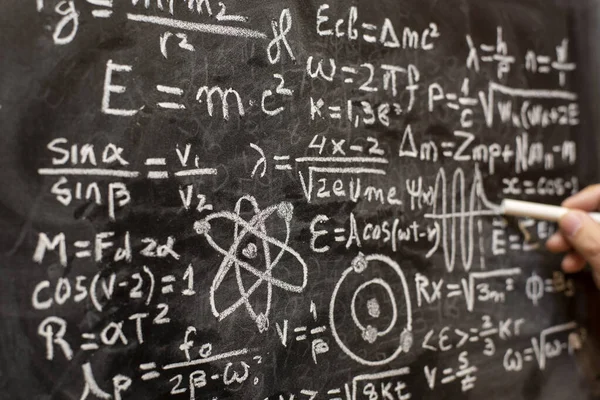 Quantum physics operations written by hand with a chalk on the blackboard