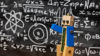 Tahtadan ve vidadan yapılmış robot yazılı formüllerle dolu bir karatahtanın önünde kuantum fiziği öğretiyor.