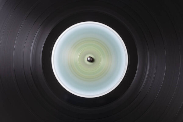 Detail of the microgrooves of an old vinyl record in motion, in color and black and white