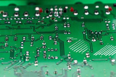 Yeşil bir elektronik levhanın birden fazla yazdırılmış devrelerinin ayrıntıları
