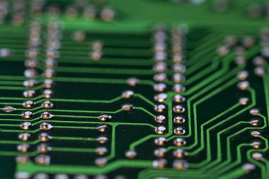 Yeşil bir elektronik levhanın birden fazla yazdırılmış devrelerinin ayrıntıları