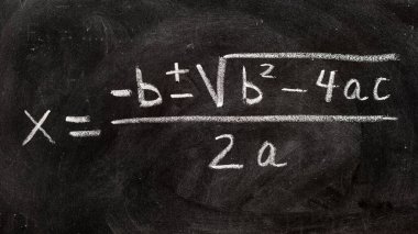 Karatahtaya tebeşir ve matematiksel formüllerle el yazısıyla yazılmış ikinci dereceden denklemler