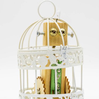 Tahta oyuncak robot bir kafese kilitlendi, beyazlar içinde izole edildi.