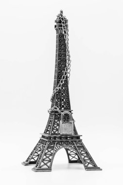 Minyatür Eyfel kulesi, beyaz üzerine izole edilmiş zincir ve asma kilit ile kapatılmış.