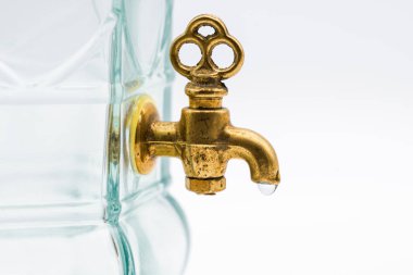 Antika bronz bir musluğun ayrıntıları. Bir damla suyla birlikte, beyaz üzerine izole edilmiş.