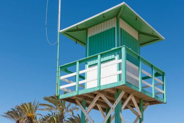 Akdeniz 'in bir sahilinde, arka planda mavi gökyüzü olan cankurtaran kulübesi.