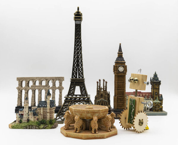 Wooden artisan robot next to several world monuments such as the Eiffel Tower, Patio de los Leones de la Alhambra or Big Ben