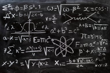 Matematiksel işlemler ve kuantum fiziği formülleri tahtaya tebeşirle yazılmış.
