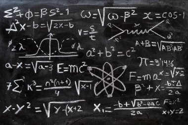 Matematiksel işlemler ve kuantum fiziği formülleri tahtaya tebeşirle yazılmış.