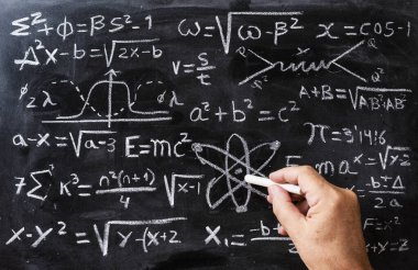 Tahtada tebeşirle el yazısı matematiksel işlemler ve kuantum fiziği formülleri