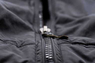 Kapalı siyah bir ceketin fermuarı.