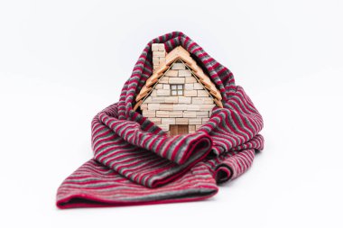 Eşarba sarılı minyatür ahşap bir ev, beyaz üzerine izole edilmiş.