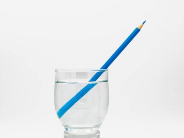 Renkli kalemlerle dolu bir bardakta yansıtılan ışık kırılması.