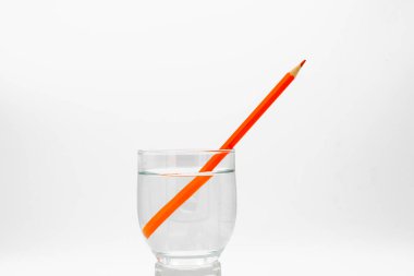 Renkli kalemlerle dolu bir bardakta yansıtılan ışık kırılması.